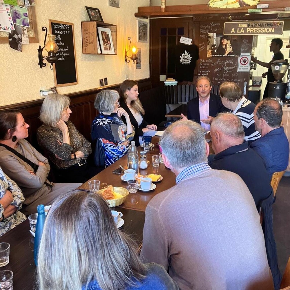 Dans la salle boisée du café, le syndic François Armada s’adresse aux participants réunis autour d’une longue table.