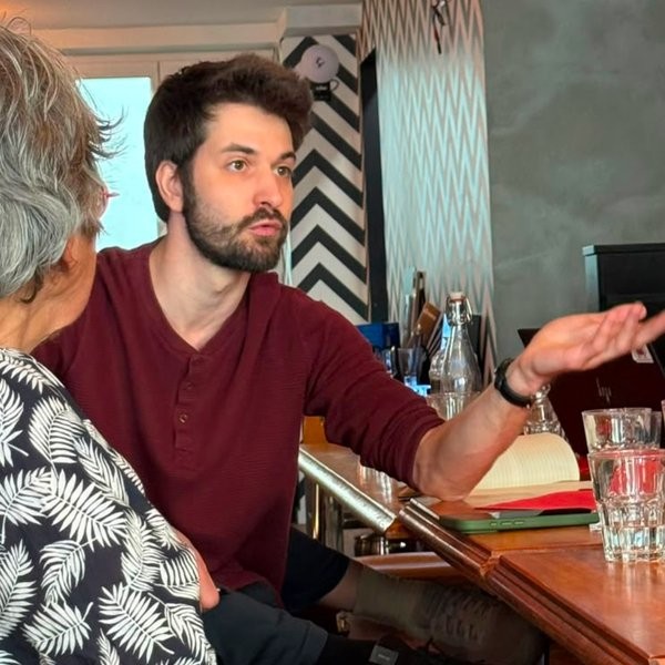 Accoudé à une table du bar, un jeune homme barbu raconte son engagement en accompagnant ses mots d’un geste de la main.